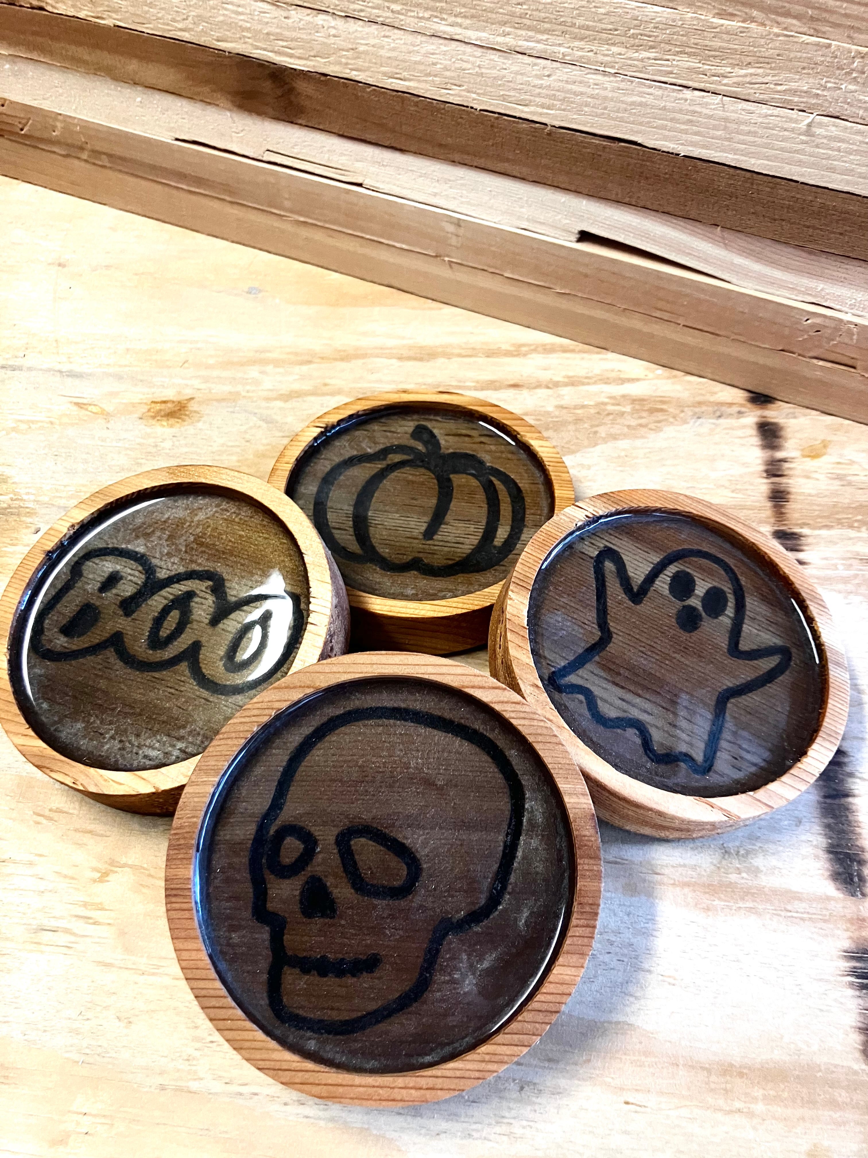 Willy's Woods presents Customized Round Cedar Coasters featuring four Halloween-themed designs: a skull, ghost, pumpkin, and "Boo" in a playful font. Crafted from top-quality cedar wood, these coasters add a festive touch to any surface.